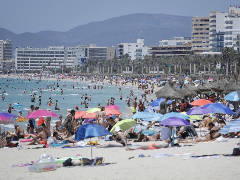 Touristen genießen die Sonne am Strand von Arenal. Corona-Reisebeschränkungen werden deutlich gelockert oder fallen ganz. Nach zwei harten Jahren schöpft die Tourismusbranche Hoffnung. Das Vorkrisen-Niveau rückt näher. (zu dpa «Tourismus auf dem Weg zum Comeback - Buchungen ziehen an») Foto: Clara Margais/dpa