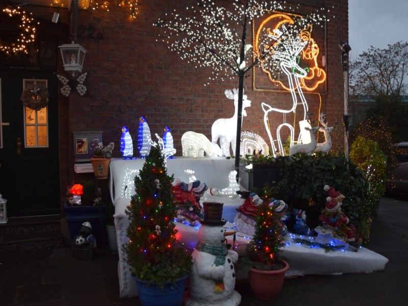 Hier sieht es richtig weihnachtlich aus., Figuren schmücken den Eingang der Krauses., An der Hauswand leuchten Bilder., Das Haus leuchtet von ganz oben bis unten.