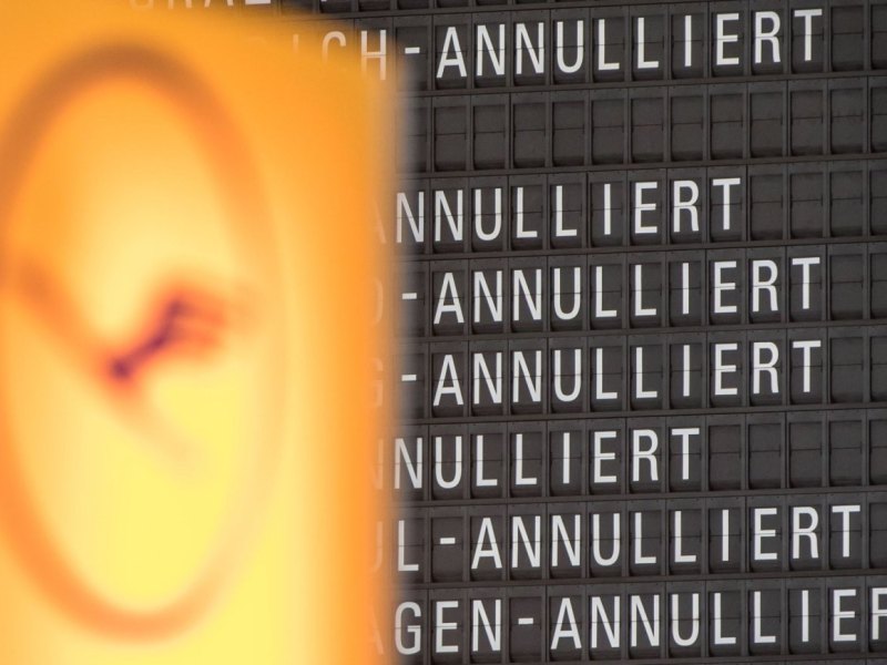 Das Lufthansalogo vor einer Anzeigetafel