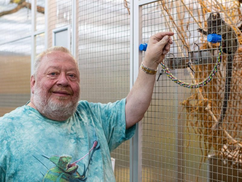 Norbert Zajac vom Zoo Zajac in Duisburg vor einem Vogelkäfig