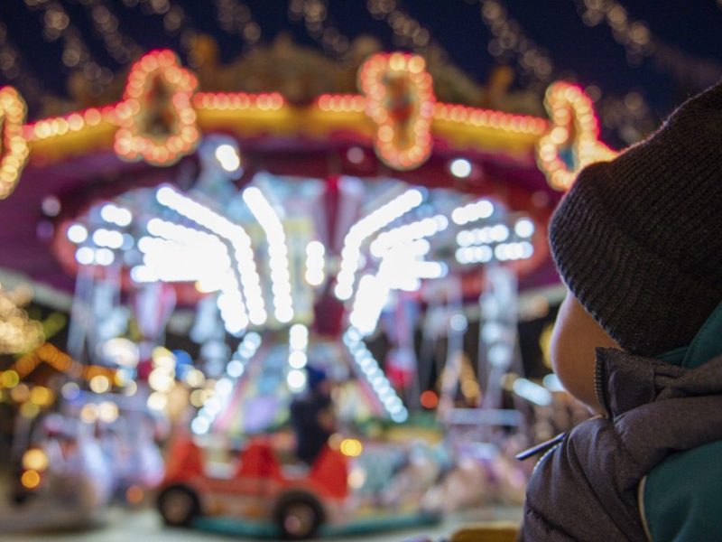 Kind blickt auf das Karussell auf dem Essener Weihnachtsmarkt