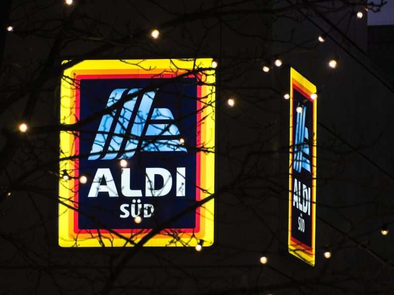 Aldi Süd Logo mit Baumästen und Lichterkette davor