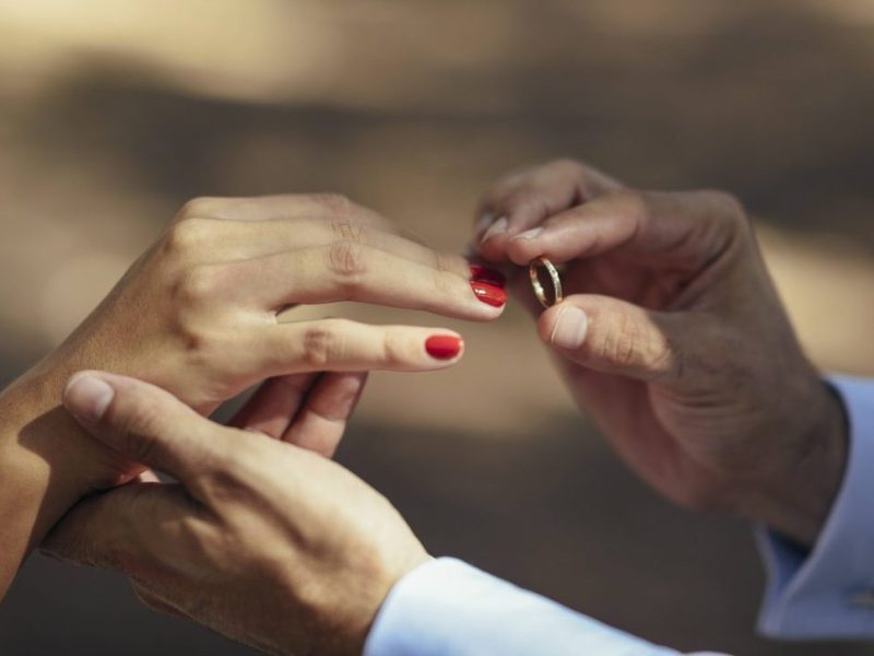 Hochzeit Bräutigam steckt Braut Ring an den Finger