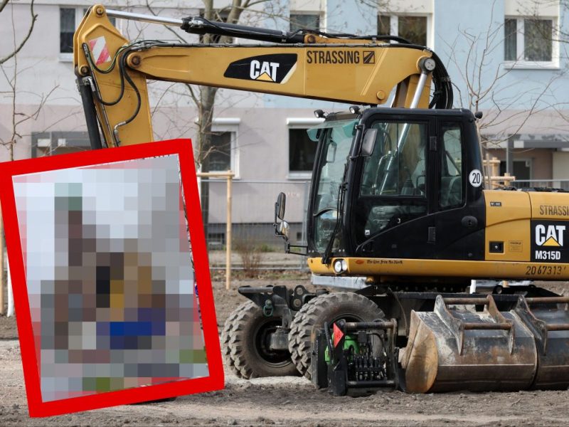 Bagger vor Mehrfamilienhaus