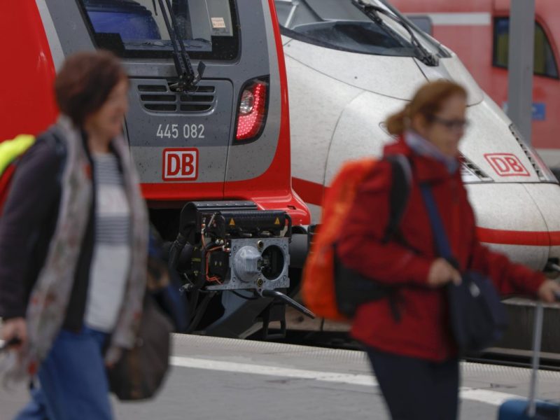 Züge der Deutschen Bahn am Gleis, Fahrgäste mit Gepäck davor
