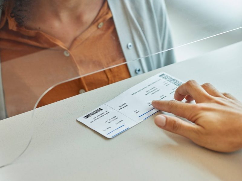 Frau am Flughafenschalter bekommt ihre Ticket