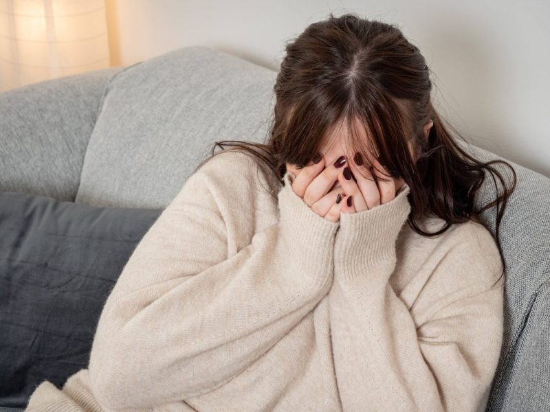 Frau hält sich die Hände vors Gesicht