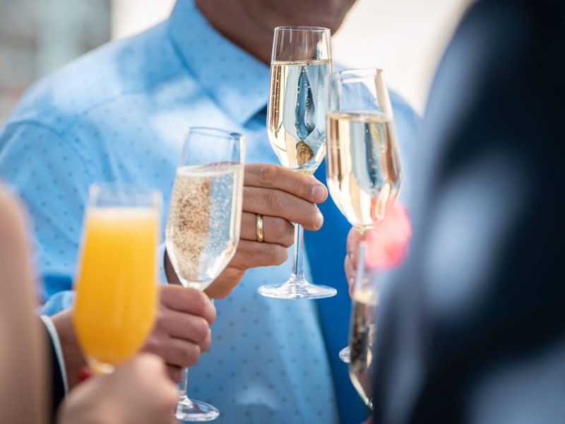 Hochzeitsgäste stoßen an mit Sekt und Orangensaft