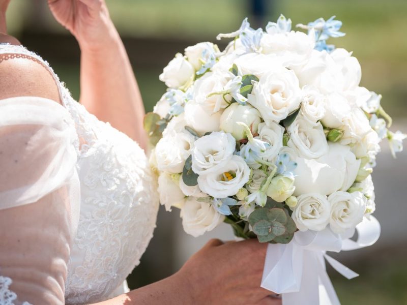 Braut in Kleid und mit Strauß in der Hand