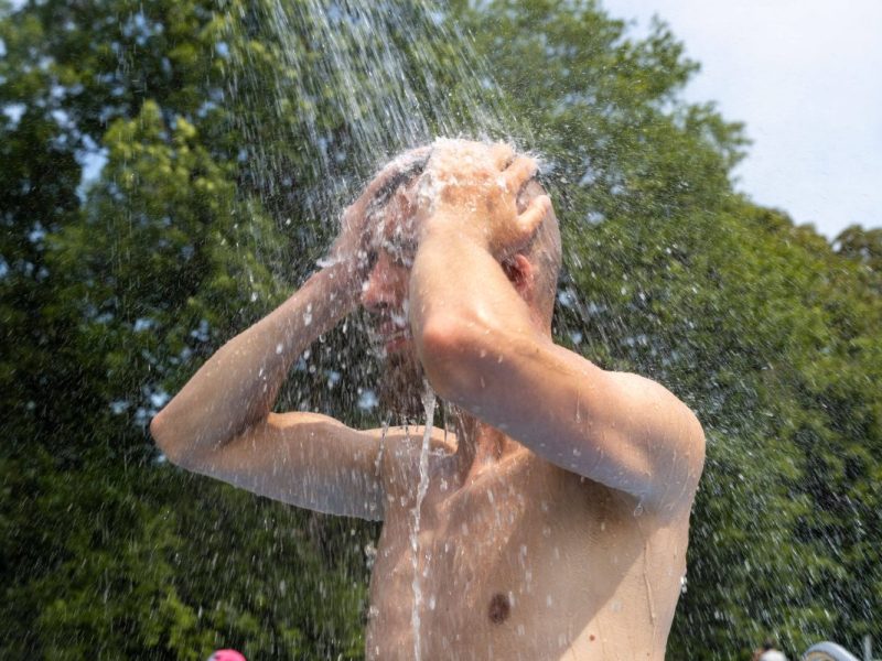 Mann duscht sich im Freibad