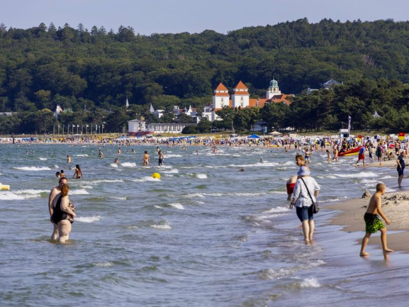 Badegäste am Strand und im Wasser im Urlaub an der Ostsee