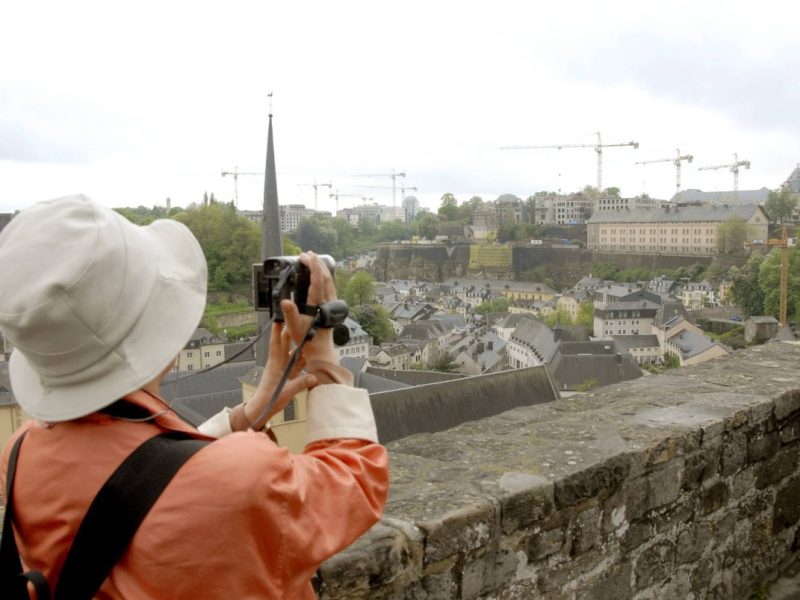 Eine Touristin filmt die historische Stadtmauer von Luxemburg.
